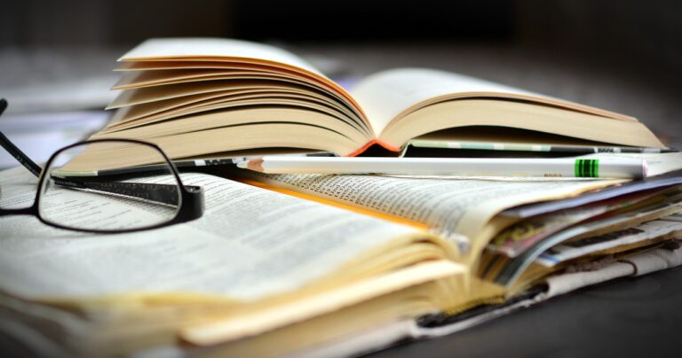 textbooks with a pair of glasses